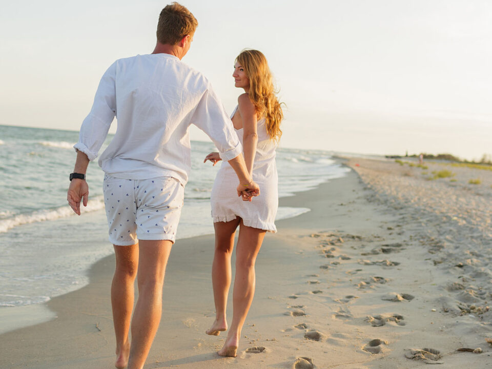 Young Beautiful Couple Walks Along The Seashore